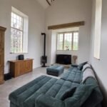 Luxury lounge with vaulted beamed ceiling and log burner at The Dragons Retreat